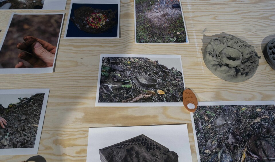 Prosessbilde av bord med diverse bildemateriale, skannet landskap på Bryn og 3D-printet landskap fra Bryn med leire fra samme sted, ROM 2022